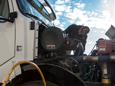 Diesel Mechanic apprentice student working on a semi engine